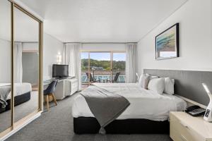 Habitación de hotel con cama y balcón en Pacific Bay Resort, en Coffs Harbour