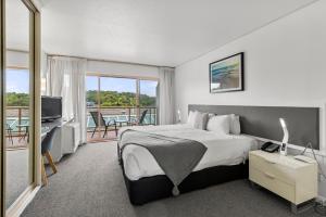 a hotel room with a bed and a balcony at Pacific Bay Resort in Coffs Harbour