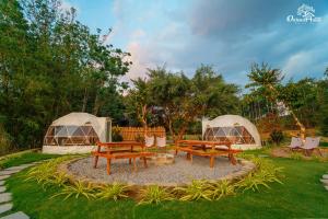 two picnic tables and two tents in a yard at Orchard Home Nam Cat Tien in Cat Tien