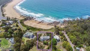 伯马吉Cuttagee Views Luxury ocean beach front Bermagui Linen & Wifi Provided的海滩与房屋和海洋的鸟瞰图