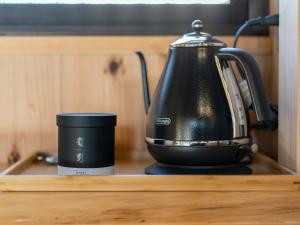 a tea kettle and a coffee cup on a shelf at 龍野城下町古民家ホテル kurasu in Tatsuno