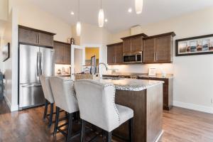 a kitchen with a large island with bar stools at 3 bed, 2 bath upper suite overlooking the city in Vernon