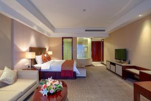 CYTS Eastern Jiading Hotel Shanghai - Original CYTS GreenTree Eastern International Hotel في Jiading: غرفه فندقيه بسرير واريكه