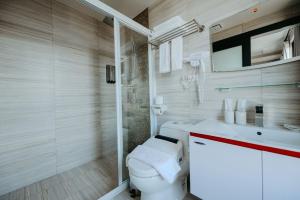 a bathroom with a toilet and a glass shower at Xien Shi Homestay in Jinning