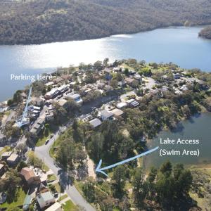 an aerial view of a house on the shore of a lake at *The Hideaway* Lake Views/Bike Storage/Smart Home/Free WiFi in Jindabyne