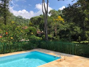 a swimming pool in a backyard with a garden at SITIO SIMPLESMENTE DEMAIS in Nova Friburgo