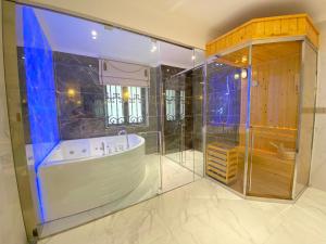La grande salle de bains est pourvue d'une baignoire et d'une douche. dans l'établissement VILLA PARK, à Kinh Dinh