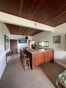 a kitchen with a counter and chairs in a room at Casa da Serra Negra in Bezerros