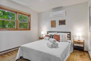 Un dormitorio blanco con una cama con toallas. en Spacious 4-BR-LG Fenced Backyard and Patio, en Summerset