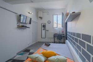 ein Zimmer mit einem Bett in der Mitte des Zimmers in der Unterkunft La Cloche Studio Hypercentre Mairie in Libourne