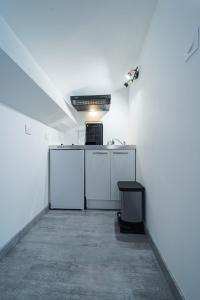 an empty room with a white kitchen with a counter at La Cloche Studio Hypercentre Mairie in Libourne