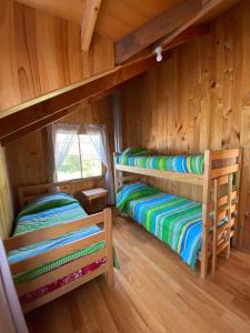 a room with two bunk beds in a cabin at Cabañas los Patitos in Pucón