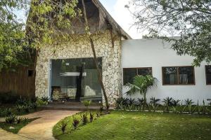 una casa in pietra con una grande finestra e un cortile di Tranquilidad y comodidad para ti a Cancún