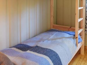 een slaapkamer met een stapelbed en een blauwe deken bij Holiday home Halden IV in Halden