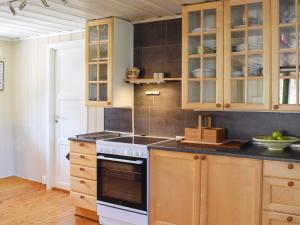 een keuken met houten kasten en een fornuis met oven bij Holiday home Halden IV in Halden