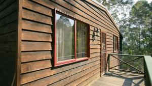 a building with a window on the side of it at Nutley Cottage with river view Bermagui Linen provided in Bermagui