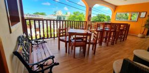 un restaurante con mesas de madera y sillas en el balcón en Hotel Bacalar Magico, en Bacalar