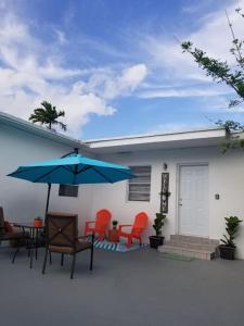 un patio con sillas y una sombrilla azul y una casa en My Nautical Paradise in Miami, en Miami