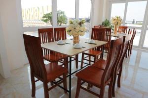 a dining room with a table and chairs with flowers on it at Magnolia Hotel Cam Ranh in Cam Ranh