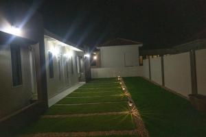 um quintal com relva verde à noite com luzes em Pavia's Centerpoint Oasis em Oranjestad