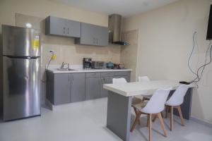 een keuken met een koelkast en een tafel en stoelen bij Pavia's Centerpoint Oasis in Oranjestad