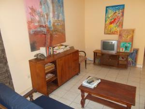 a living room with a blue couch and a tv at Hôtel Alizé Plage in Baguida