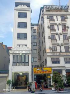 two tall white buildings next to each other at Ngọc Tùng Hotel in Ha Long