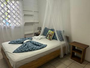 a bedroom with a bed with pillows and a net at White Son house, a pasos de la playa, 50MG WIFI in Punta Uva