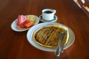 a table with two plates of pancakes and a cup of coffee at Rasti 2 homestay in Kuta Lombok +12 photos