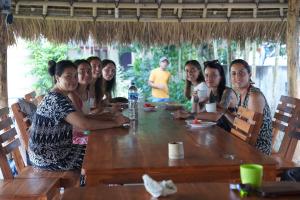 a group of women sitting around a wooden table at Rasti 2 homestay in Kuta Lombok