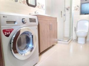 een wasmachine in een badkamer met een toilet bij Private home in Flic en Flac - quiet location in Flic-en-Flac