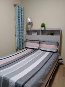 een bed in een slaapkamer met een blauw raam bij Private home in Flic en Flac - quiet location in Flic-en-Flac