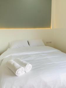 a white bed with two rolled towels on it at Suanvadee Resort สวนวดี รีสอร์ท in Don Sak