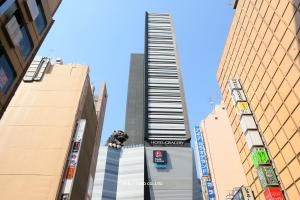 a tall building with a spiral staircase between two buildings at Hotel Gracery Shinjuku in Tokyo