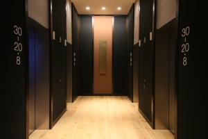 a hallway with black doors and a wooden floor at Hotel Gracery Shinjuku in Tokyo