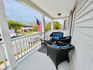 un porche con sillas, una mesa y una bandera americana en Alwaves Family 3 Bedroom Beach Apartment en Wildwood