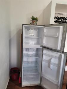 an empty refrigerator with its door open in a kitchen at VILLA DEL CIELO TIXPEHUAL in Tixpehual