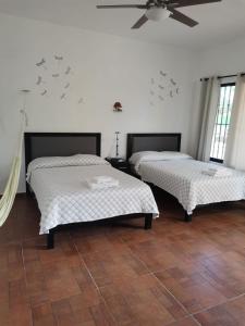 a room with two beds and a ceiling fan at VILLA DEL CIELO TIXPEHUAL in Tixpehual