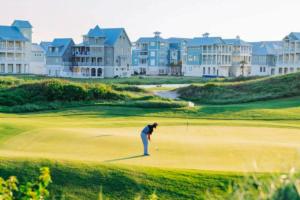 a woman is playing golf on a golf course at Fairway to Heaven in Port Aransas