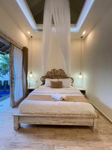 a bedroom with a large bed with a canopy at Villa deluna in Jimbaran