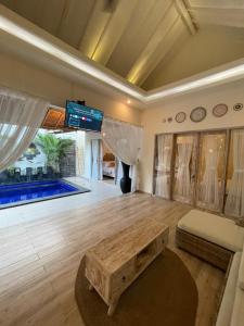 a living room with a table and a pool at Villa deluna in Jimbaran