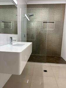 a white bathroom with a sink and a shower at Lily Pad Beach House in Agnes Water +20 photos