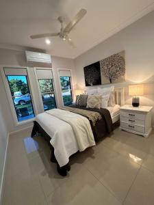 a bedroom with a large bed and windows at Lily Pad Beach House in Agnes Water