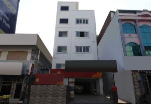 ein hohes weißes Gebäude neben einer Straße in der Unterkunft Flagship Hotel Sr Residency in Vijayawāda