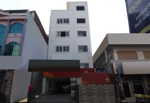 a white building in the middle of some buildings at Flagship Hotel Sr Residency in Vijayawāda