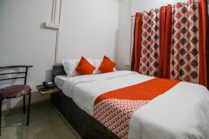 a hotel room with a bed and a chair at Jp Homes in Kamakhya