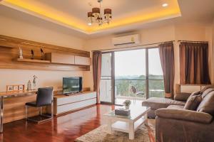 uma sala de estar com um sofá e uma televisão em Seastar Hotel and Service Apartment em Ban Chang