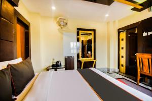a bedroom with a large bed and a mirror at Meera International in Āsansol