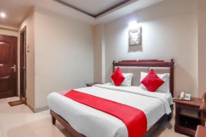 een slaapkamer met een groot bed met rode kussens bij Grandeur By Orbit Hotels Near Chennai Shopping Mall in Hyderabad