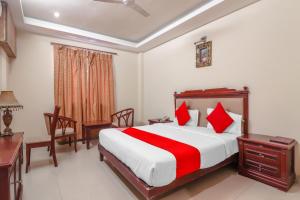 een hotelkamer met een bed, een bureau en stoelen bij Grandeur By Orbit Hotels Near Chennai Shopping Mall in Hyderabad